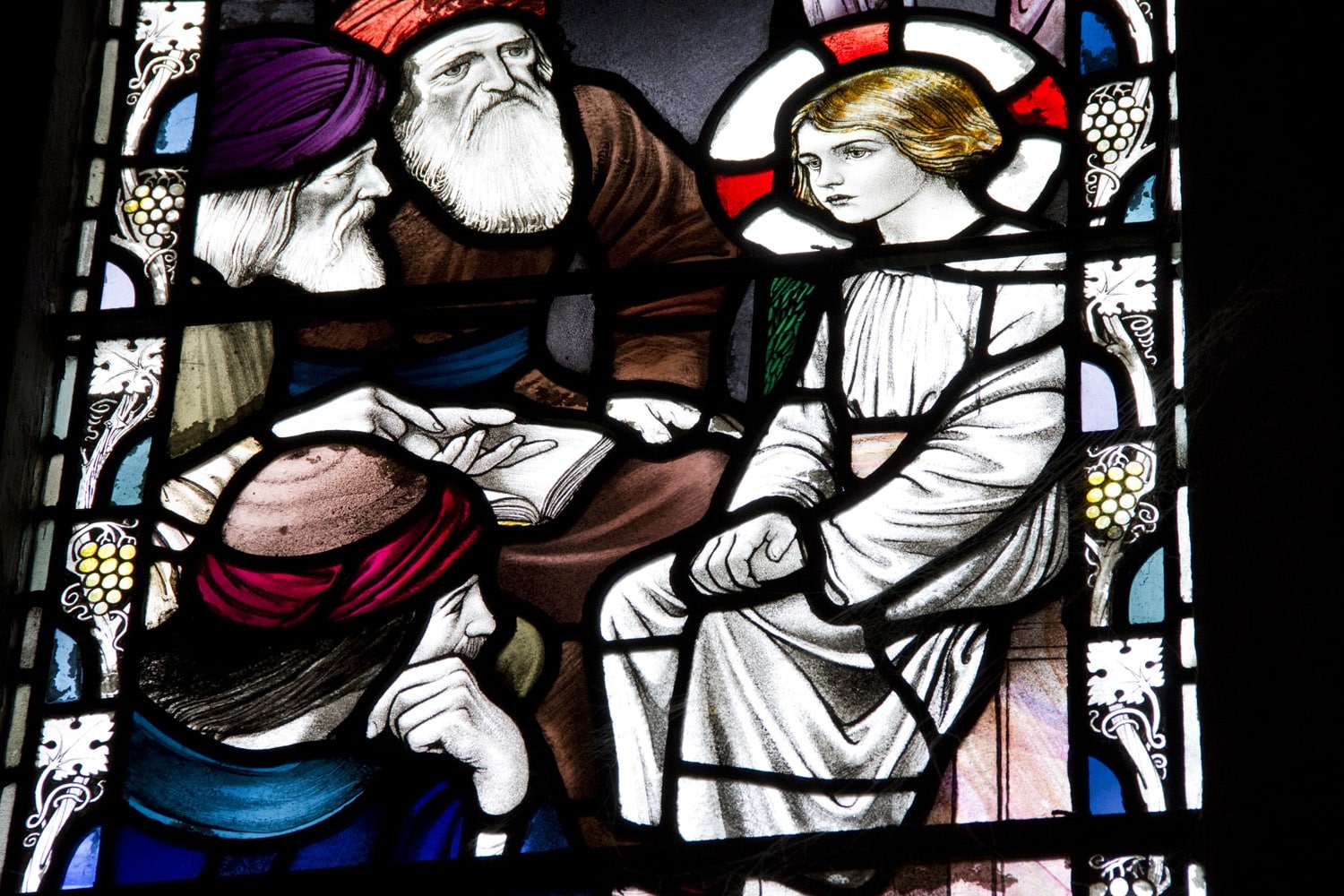 A stained glass window of four people from biblical times